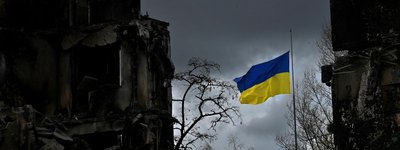 A Ukrainian flag flies between houses destroyed by shelling in the Ukrainian town of Borodyanka