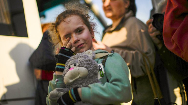 Дитина, яка з її родиною евакуювалася з Маріуполя, прибуває до центру прийому переміщених осіб у Запоріжжі, 8 травня 2022 року - фото 1