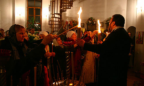 Священик Олександр Білокур роздає Благодатний вогонь своїй пастві