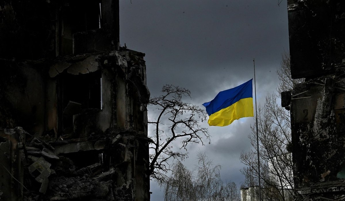 A Ukrainian flag flies between houses destroyed by shelling in the Ukrainian town of Borodyanka - фото 1