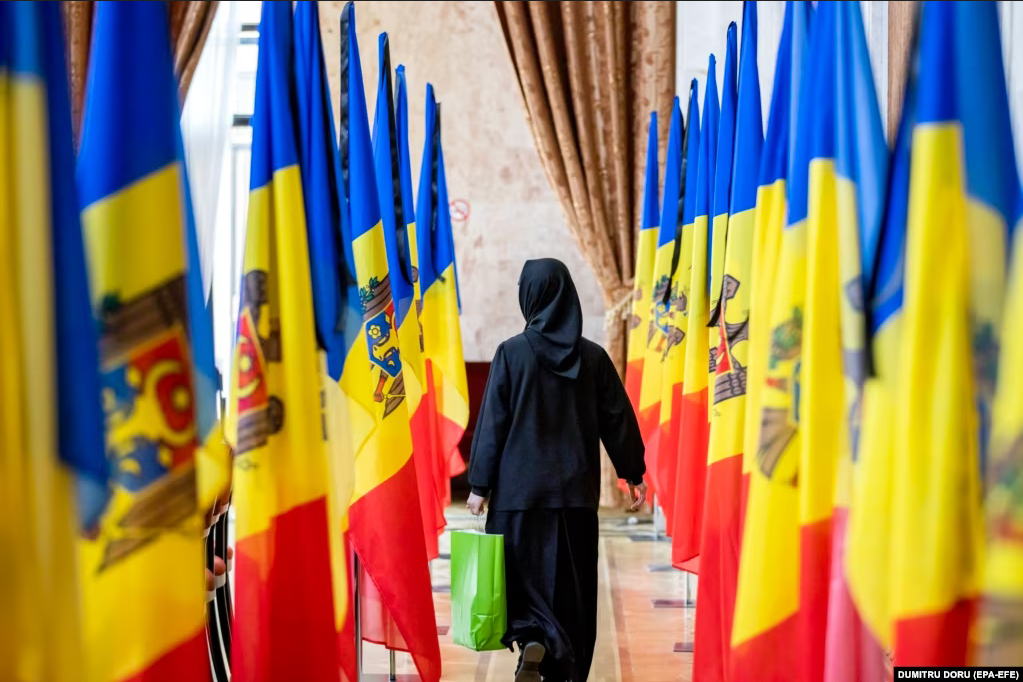 Черниця проходить повз прапори Молдови - фото 124977