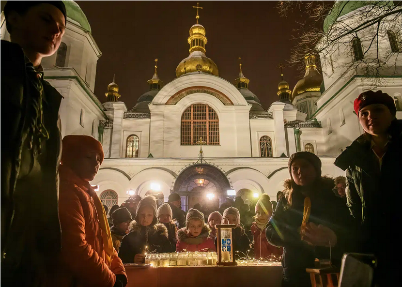 People celebrate the arrival of the Peace Light of Bethlehem outside St. Sophia Cathedral in Kyiv, Ukraine to launch the 2023 Christmas season. - фото 130030